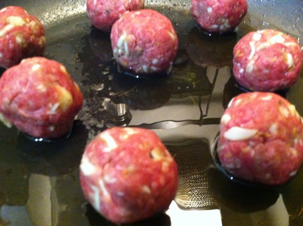 Put a few into preheated olive oil in a flat pan. Here's where you have to move fast because you don't want them to stick. Roll them around and brown lightly on all sides so you don't see pink.