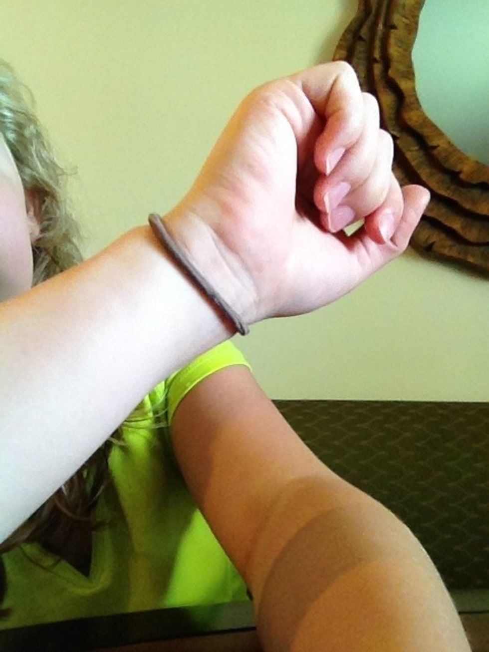 Put a hair tie on the hand you put up with ponytails, as if you were putting your hair in a ponytail