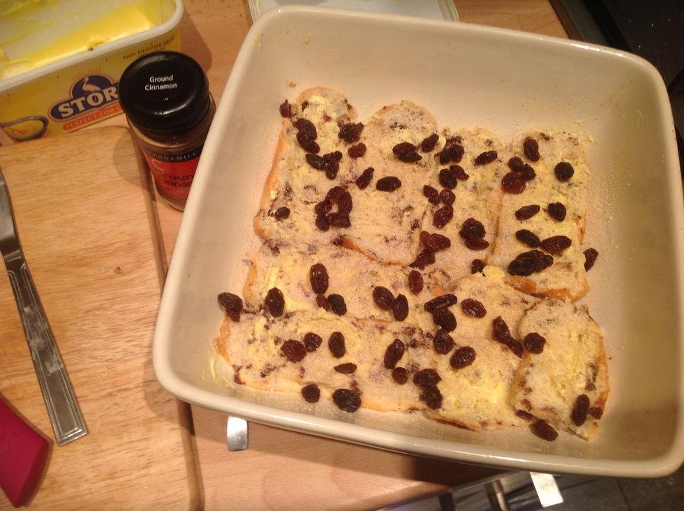 Put a handful of raisins and a third of the sugar over the top of the layer of brioche