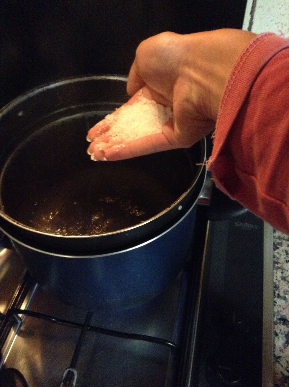 Put a handful of salt into a pot with boiling water.
