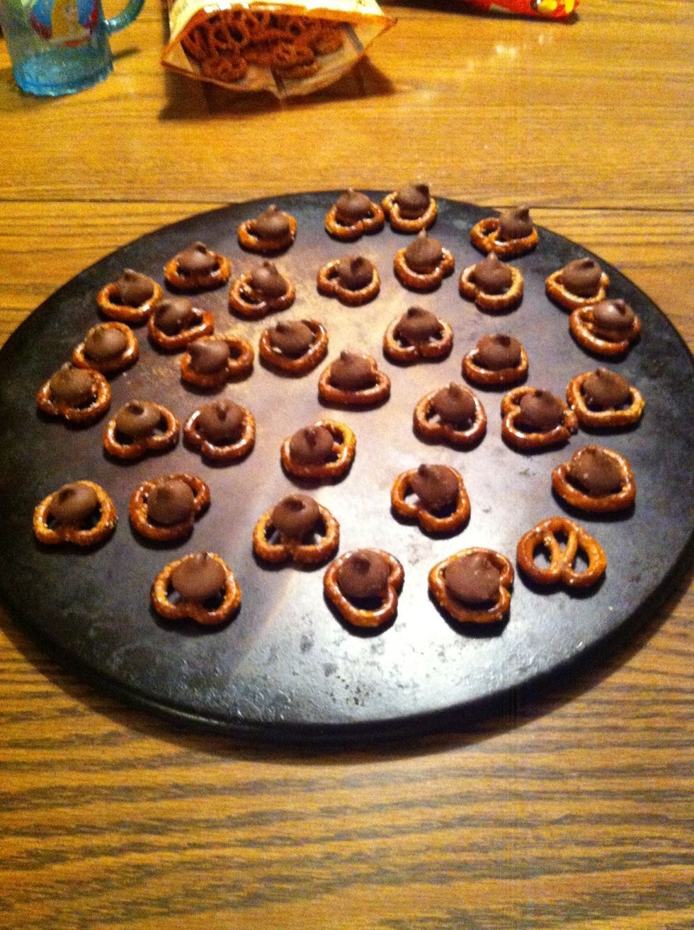 Put a Hershey kiss on the center of each pretzel.