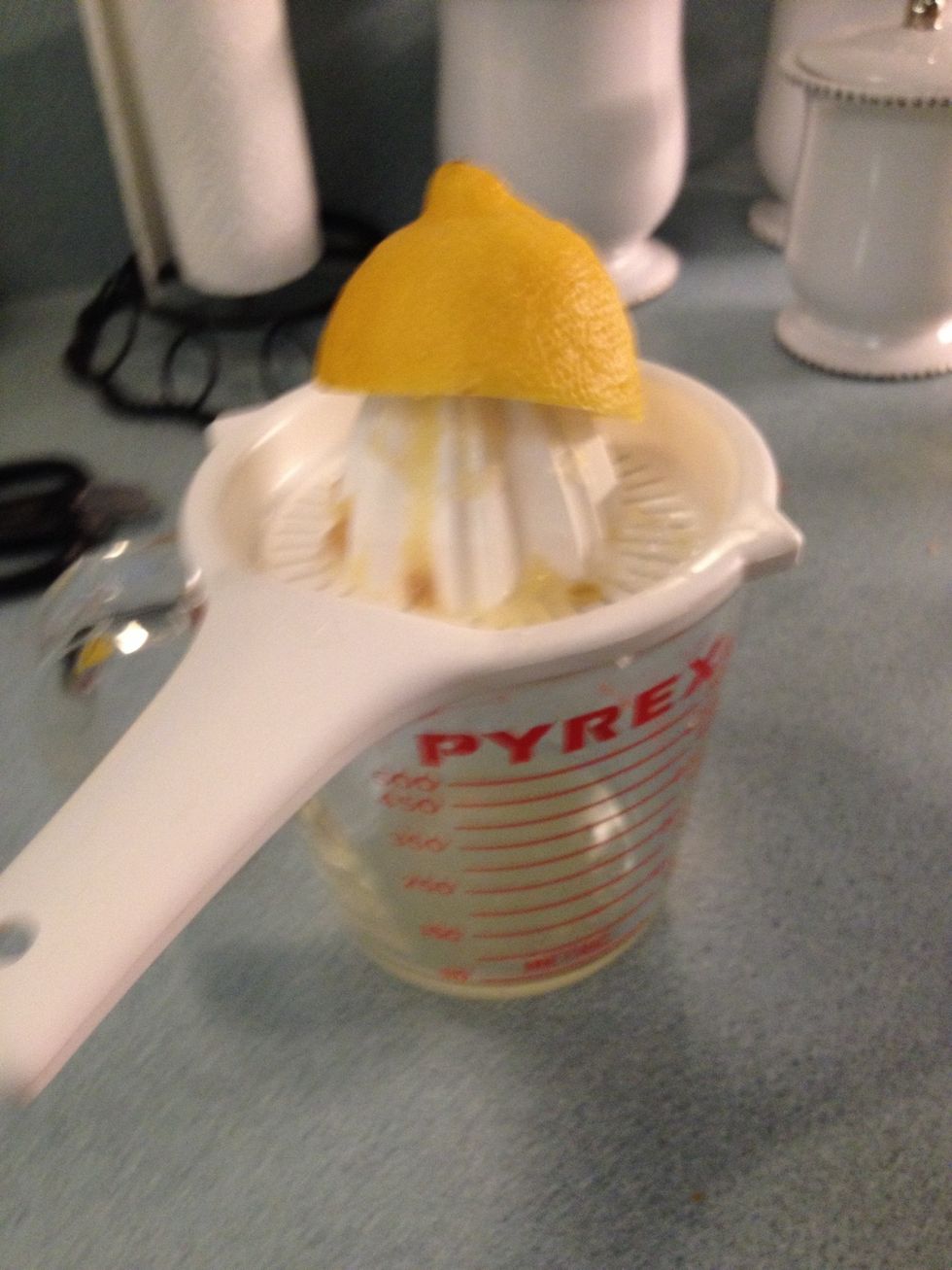 Put a juicer on top of a measuring cup. Cut the lemon in half and use the juicer to get the juice of 1 lemon.
