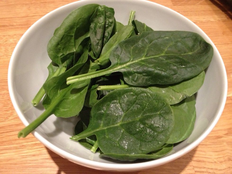 Put a large handful of spinach into a microwaveable bowl