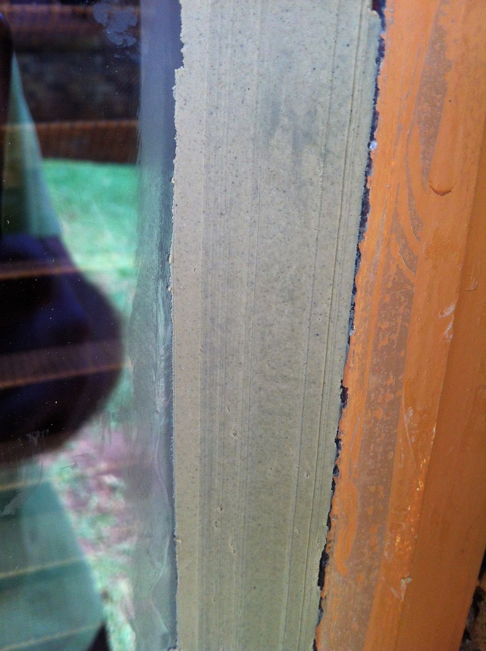 Put a layer of putty against window and frame, and smooth with paint scraper