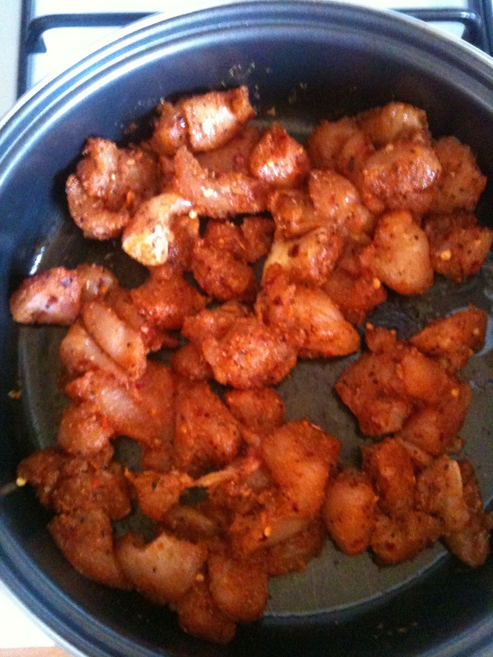 Put a little oil in the pan heat up the pan and add the chicken and cook until its nearly cooked if the pan becomes dry add some more oil cook for about 10 mins on medium heat