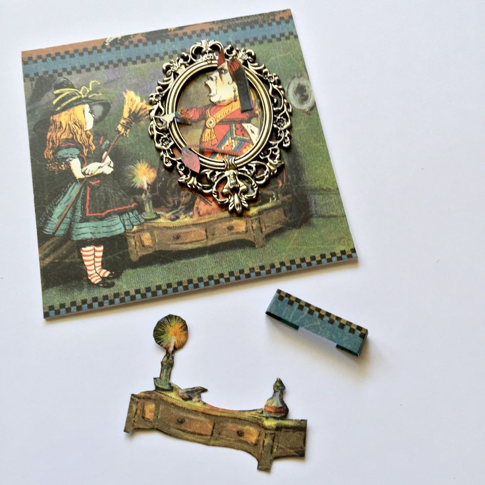 Put a metal frame and let hand's queen out of the frame. Glue the face and let upper side out of the frame too. Make a little piece of paper to glue the furniture.