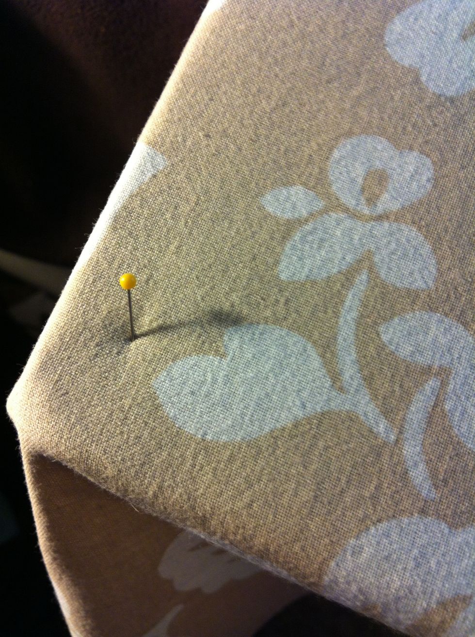 Put a pin or two every so often along the edges (or a thumbtack) to hold the fabric in place when you do the next step: securing it to the back.