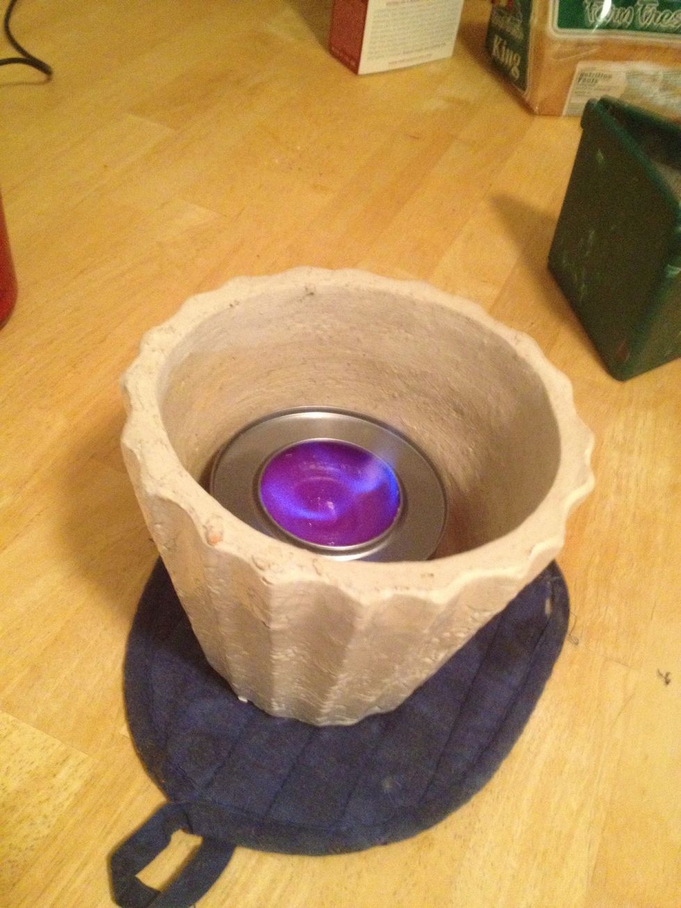 Put a pot holder under your flower pot. Place the sterno inside of the pot and light it.
