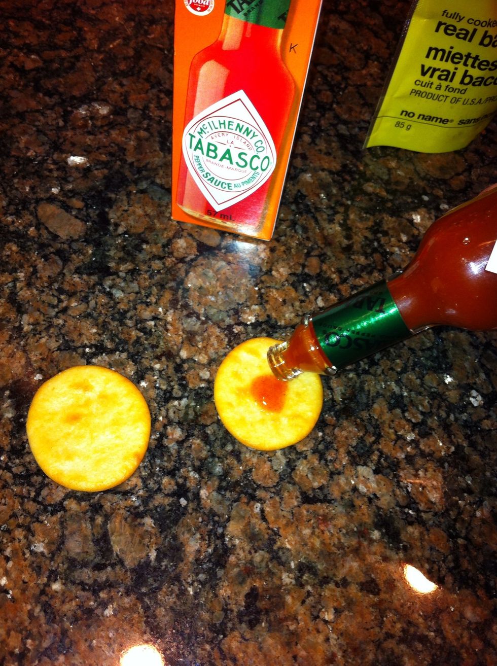 put a quite a few drops (if you like the heat) of hot sauce in the center of each cracker