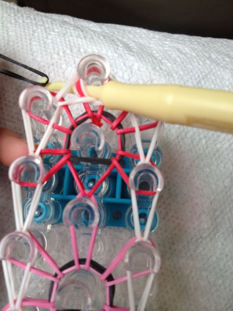 Put a rubber band on the hook, pull it through so the one rubber band is holding the bracelet on the loom. Then loop it over the hook so there is two O's on the hook.