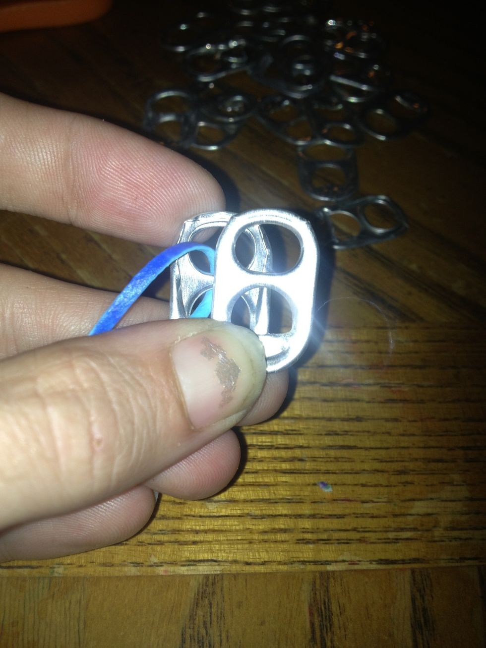 Put a soda tab (smooth side up) on top of the other soda tab.