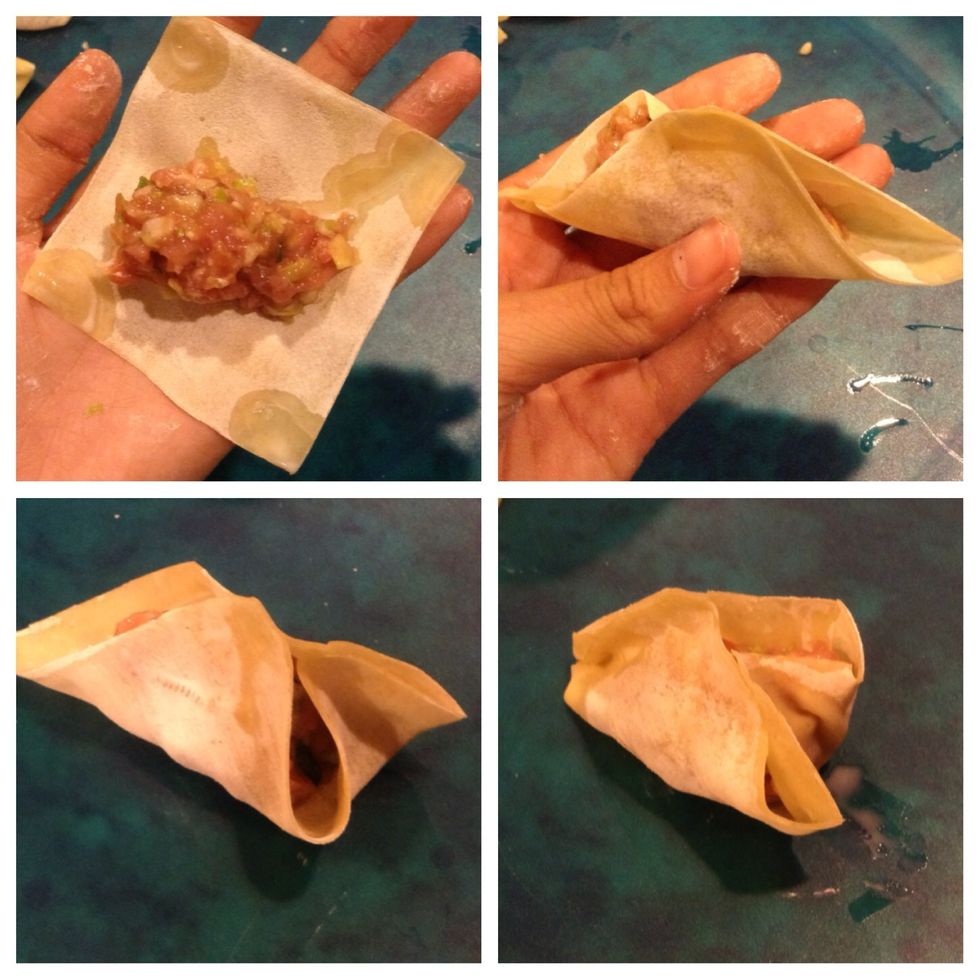 Put a spoonful of filling on a dumpling wrapper. Using your fingertip, moisten edges of dumpling with water. Fold wrapper in half, forming a half moon, and pleat the edges, pressing firmly to seal.