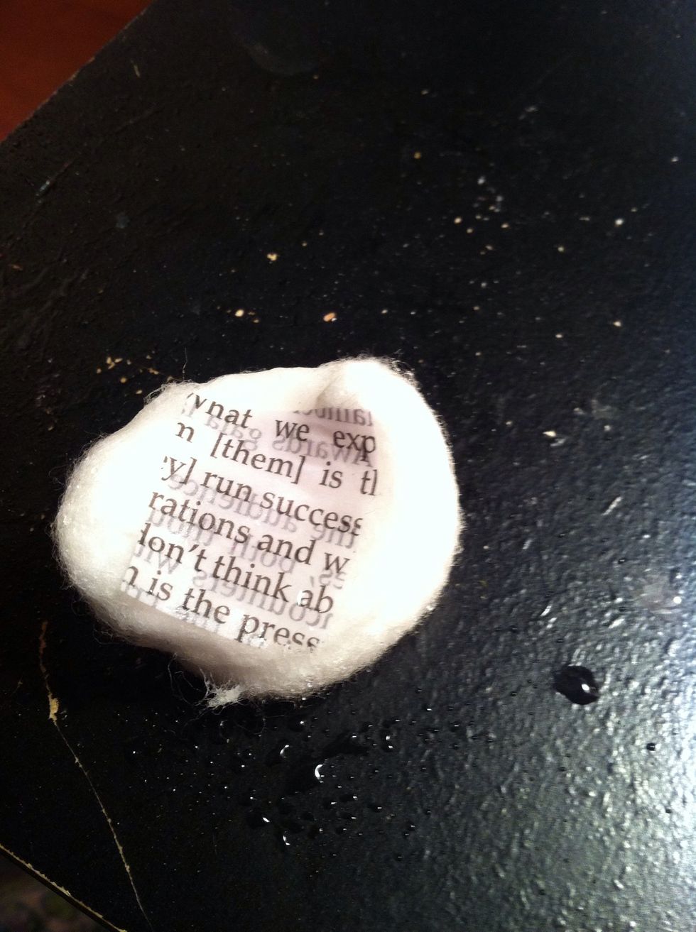 Put a square of newspaper on a damp cotton ball