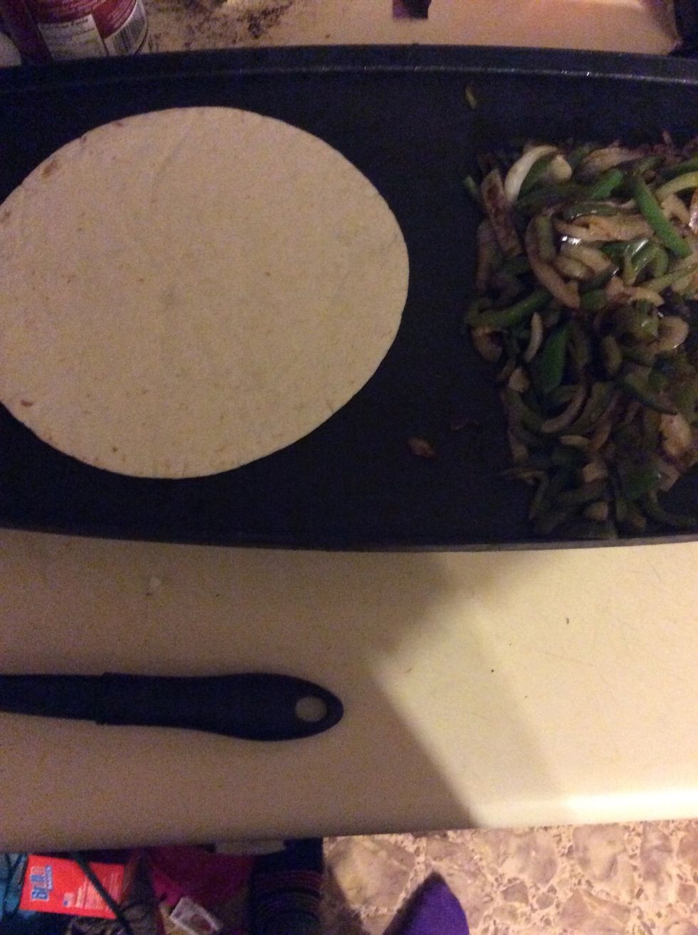 Put a tortilla on the skillet or pan with melted butter