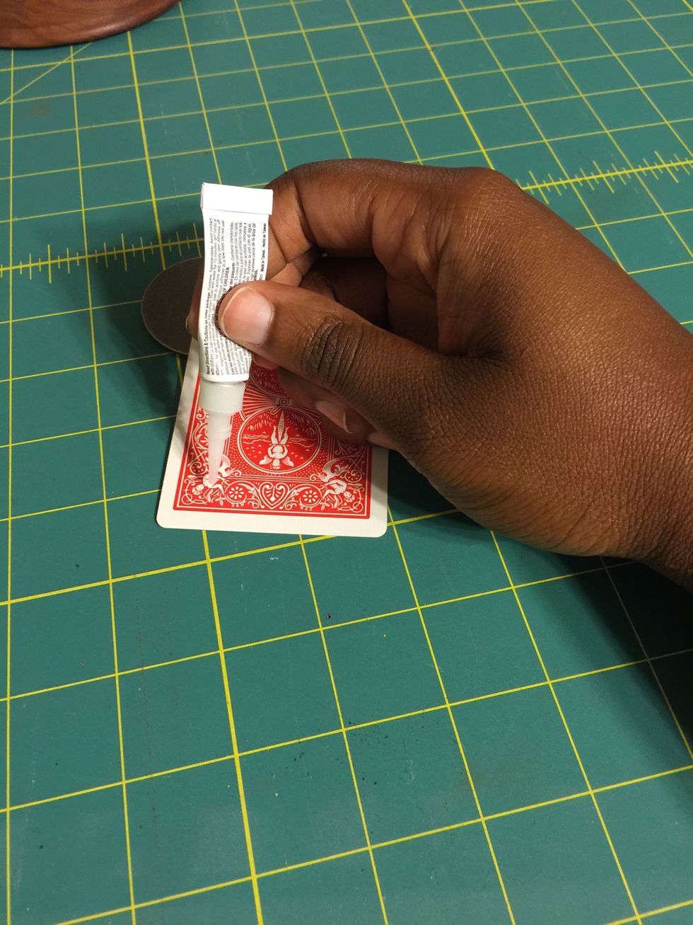 Put about two or three lines of super glue on the bottom of your playing card.