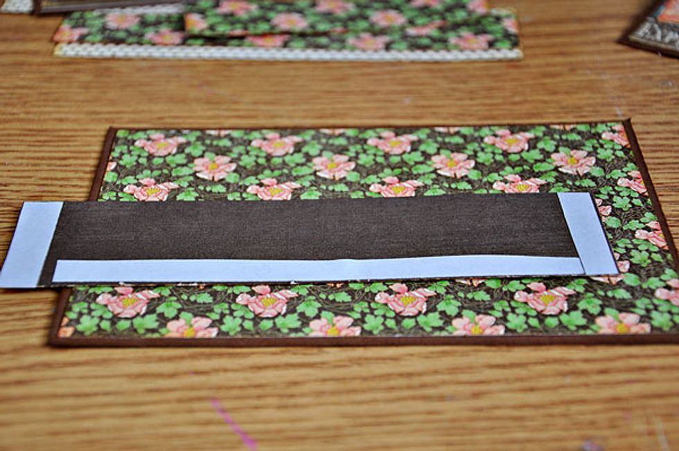 Put adhesive on the sides and bottom of the strip and adhere this on the bottom of your page. Another option is sewing the pockets on the pages.