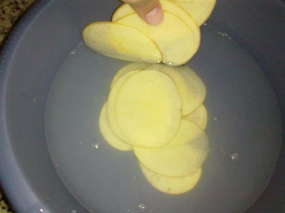 Put all potato slices in a bowl filled with water and salt and let it sit for 15 - 20 minutes