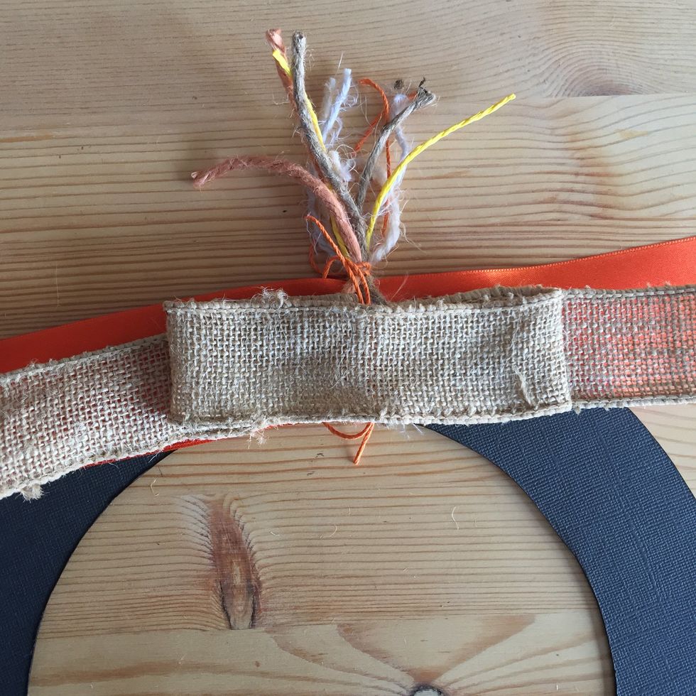 Put an orange ribbon below the one of jute.