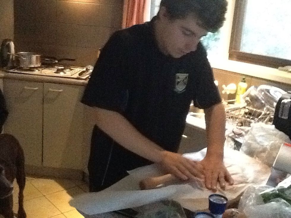 Put another piece of baking paper over the chicken and use a rolling pin to flatten it.