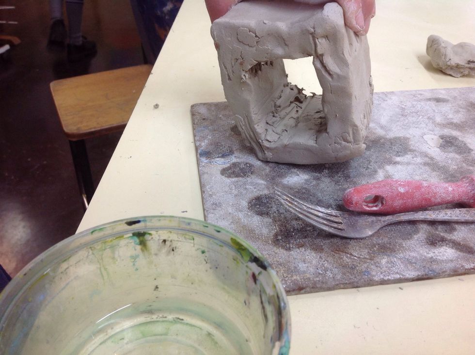 Put another piece of clay between the squares to secure the cube