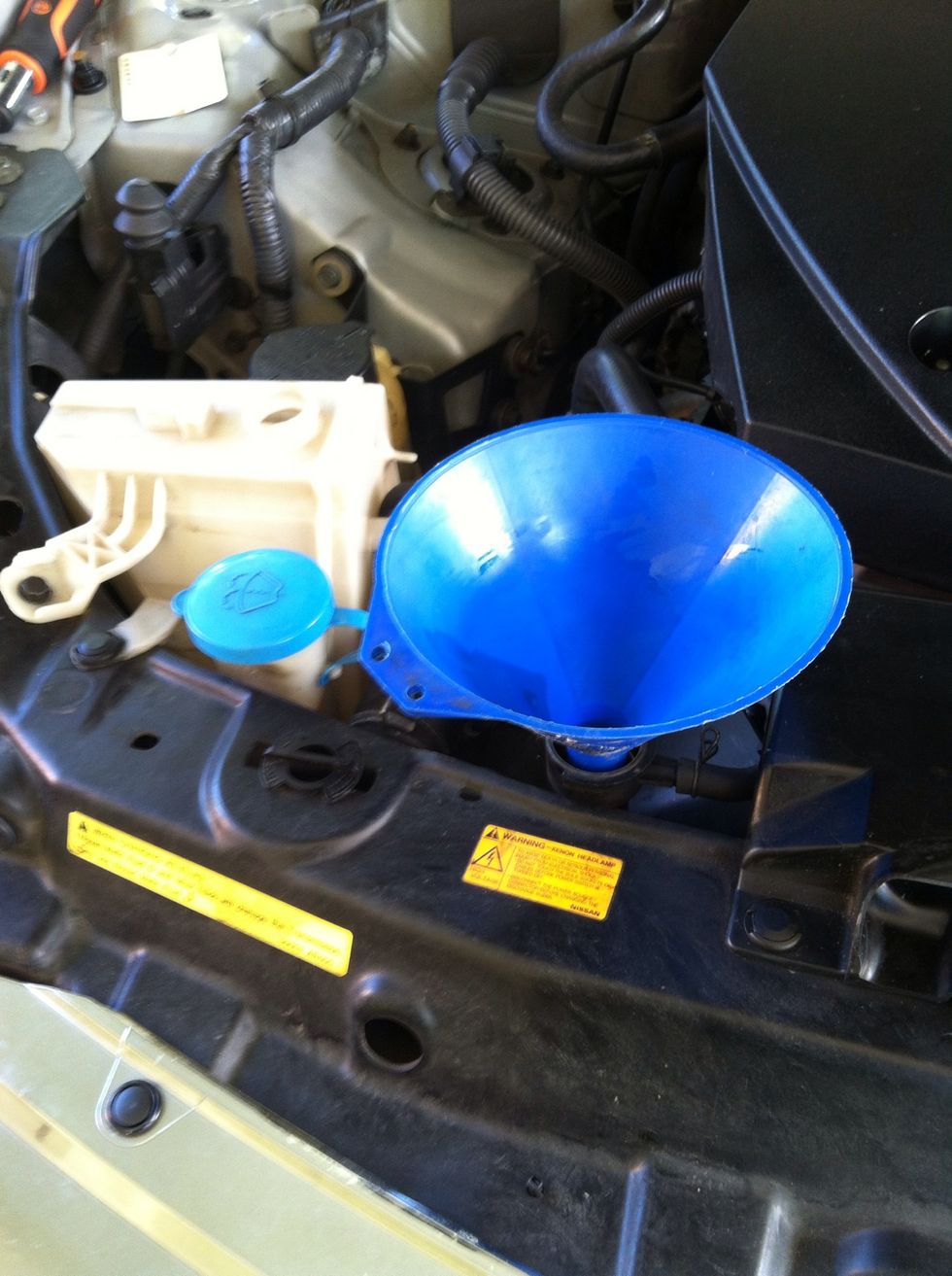 Put back the coolant container. Fill the radiator with coolant at slow pace until its reach the top. Then fill the coolant container to the MAX mark.