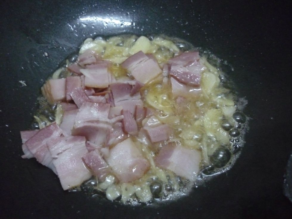 Put bacon and garlic in your pan and fry them until bacon become crispy.