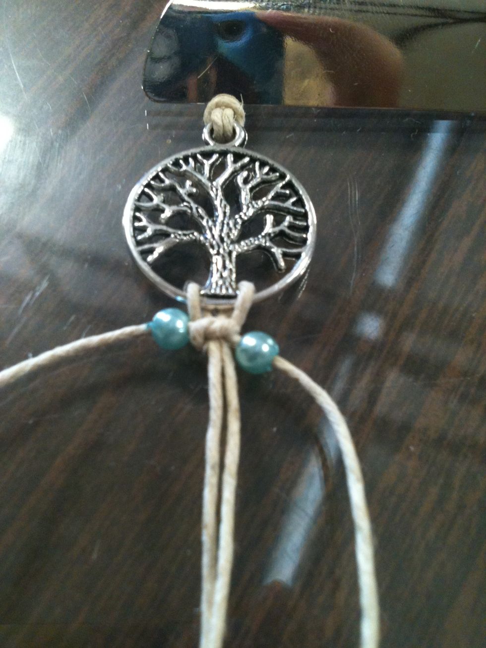 Put beads on the string. (as shown)