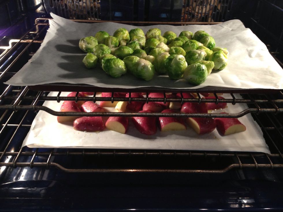 Put both trays in a cold oven. Potatoes up Brussels sprouts  under. Brussels sprouts cook faster. Here I made a mistake for the picture but I exchanged up down while cooking. Put on oven on bake 180C