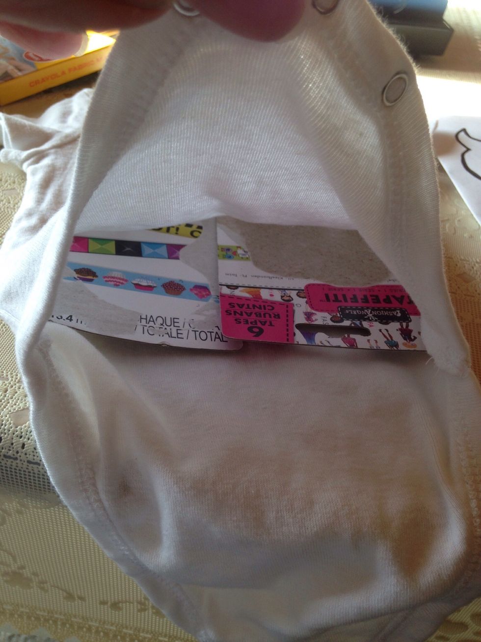 Put cardboard (cut to size) inside of onesie. You do not want the marker to seep through.