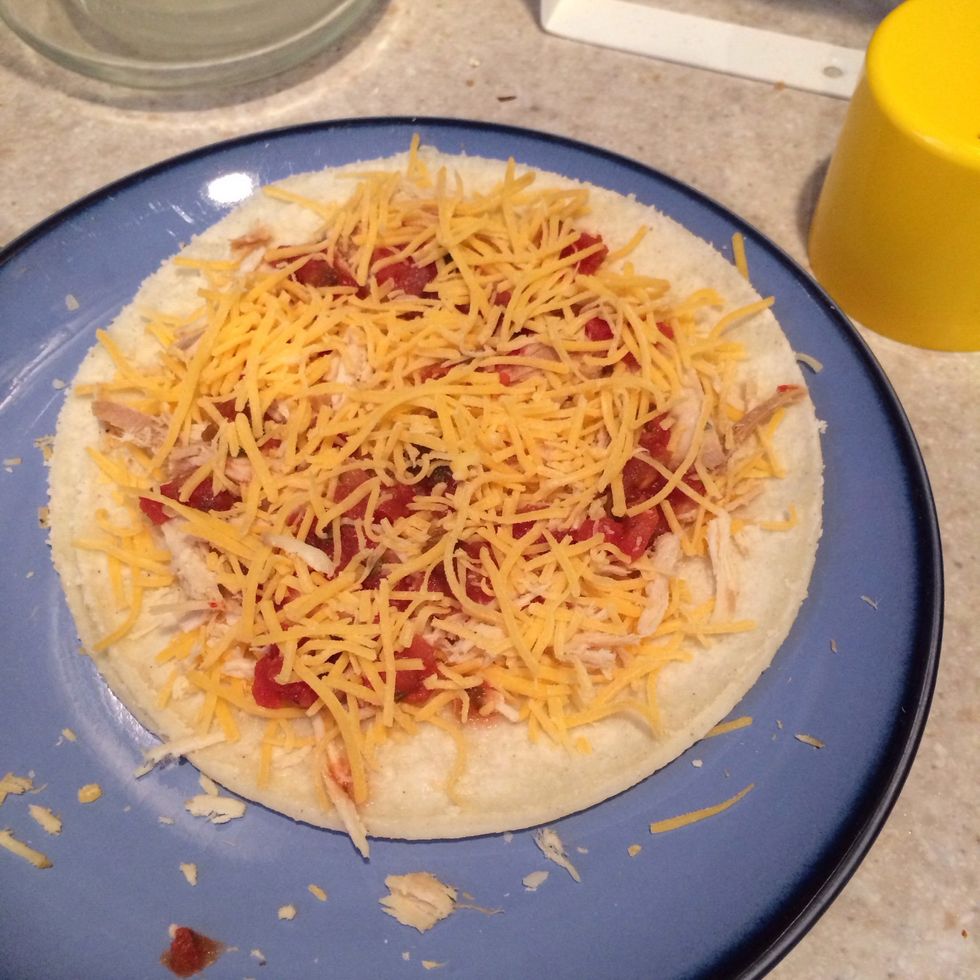 Put cheese, salsa, and shredded chicken on corn tortilla. Spread evenly. (Chicken is optional)