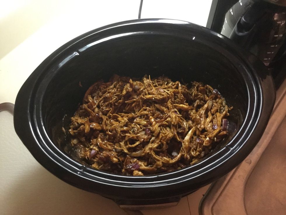 Put chicken back in slow cooker and add remaining BBQ sauce and chopped onion. Set slow cooker to low temperature and cook for one more hour.