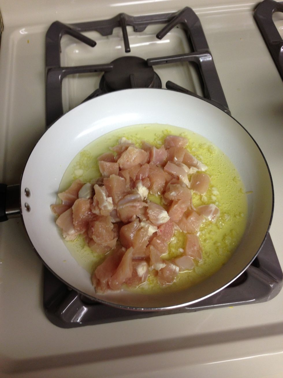 Put chicken into oil and garlic and cook about 5-10 minutes.