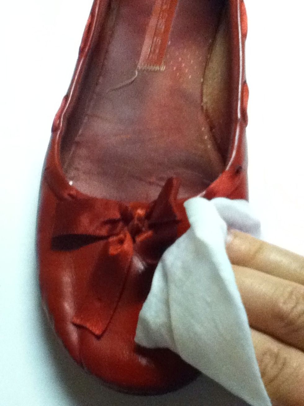 Put down paper on your work surface.Clean your shoe with the wet one