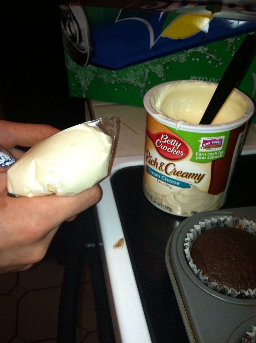 Put frosting into plastic bag and tear the tip off