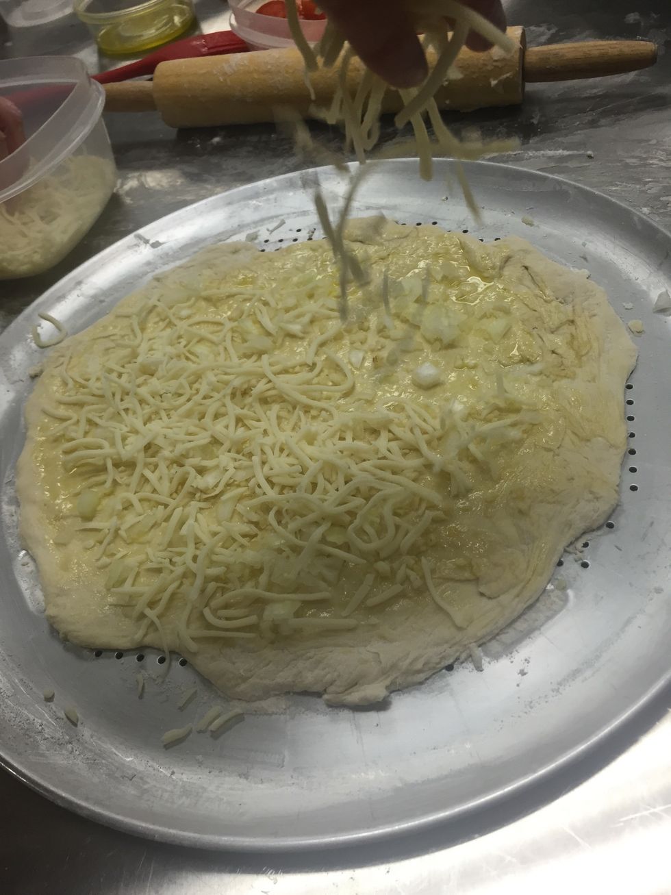 put garlic & onions on pizza, then sprinkle with mozzarella cheese