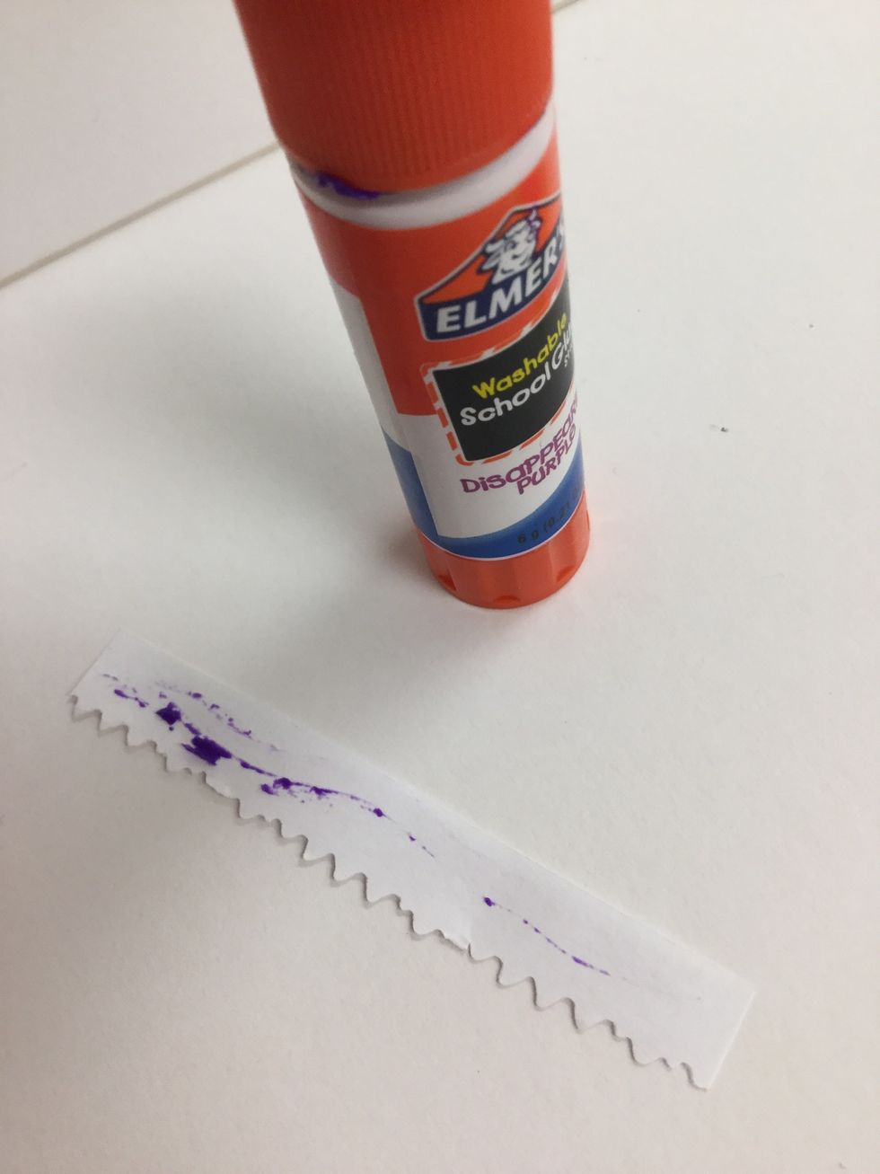 Put glue along the top of the tooth strip. Lay it inside the mouth with the glue facing up.