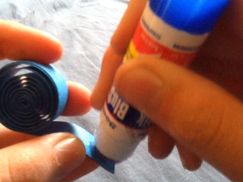 Put glue on the end of the strip then stick it together and hold it the for ten seconds.