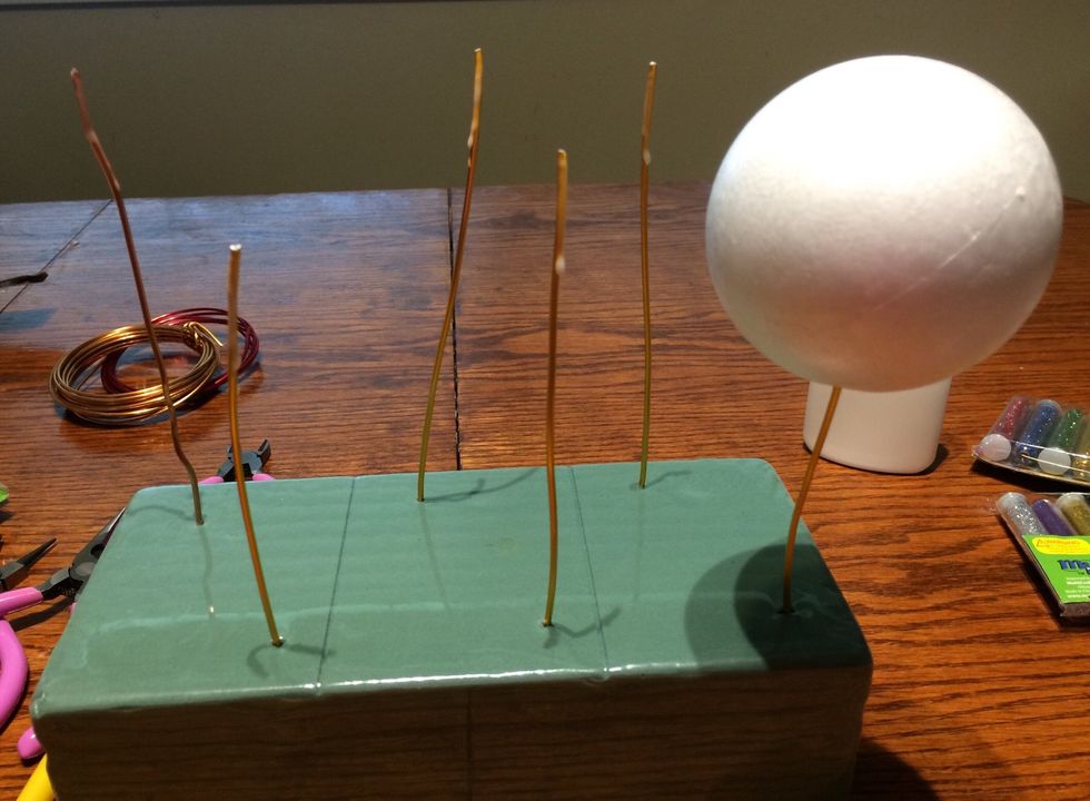 Put glue on the ends of the wires before putting the styrofoam balls onto them. Push the wire into the ball about half way, then put the wire and ball back into the foam block.