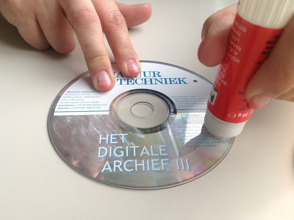 Put glue on the printed side of the CD to stick on the photo.