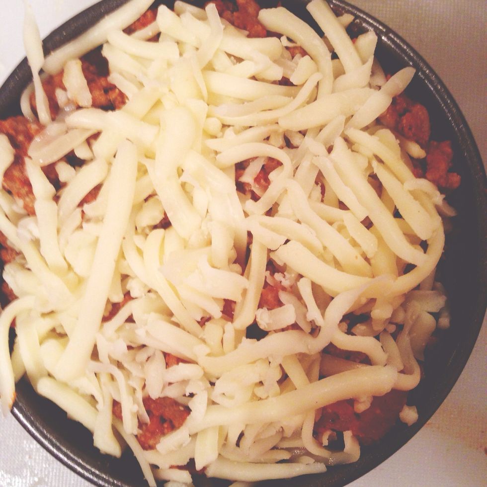 Put half of the meat/tomato/onion-sauce on top, then zucchini, rest of the meat-sauce and finally the low fat cheese on top.