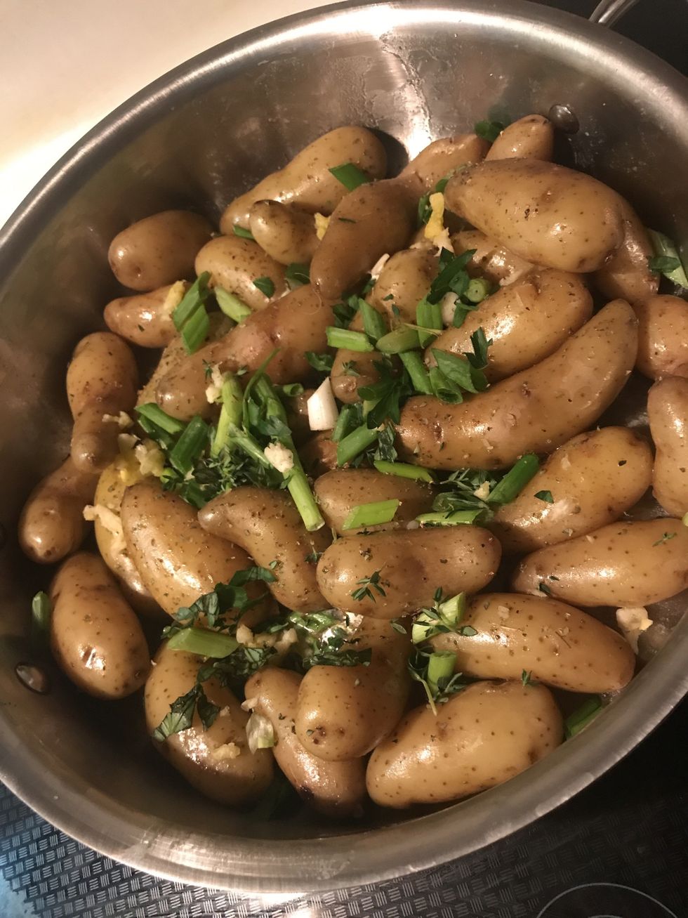 Put he pre boiled potatoes in the pan. Add green onions garlic Basil Thyme Salt Pepper Vinegar Stir and cover for 2-3 minutes