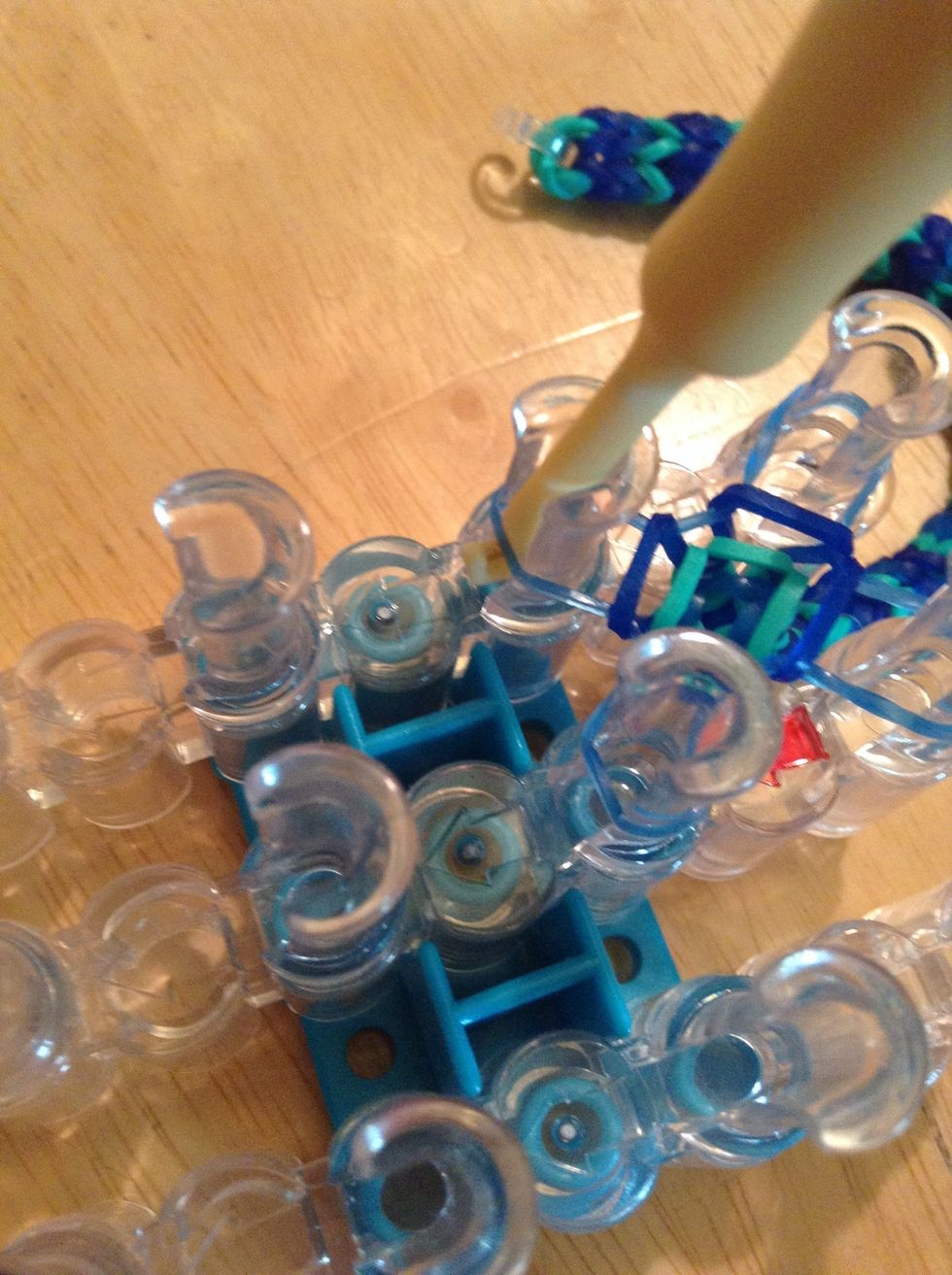 Put hook under one of the edges of the band and pull it onto the hook