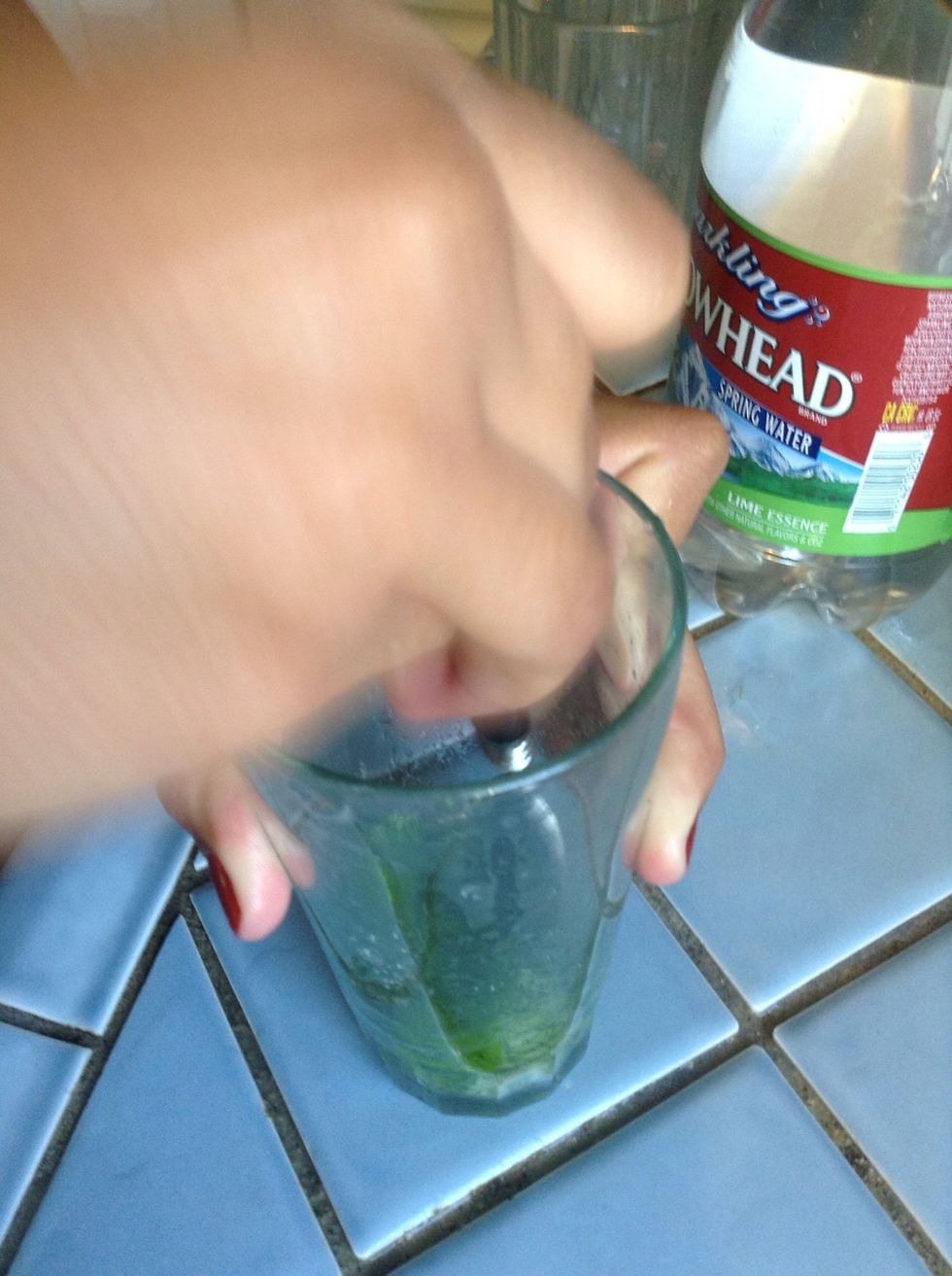 Put in the 2 springs of mint, stems and all. Muddle the leaves gently, just enough to release the mint's essential oils. DO NOT shred!