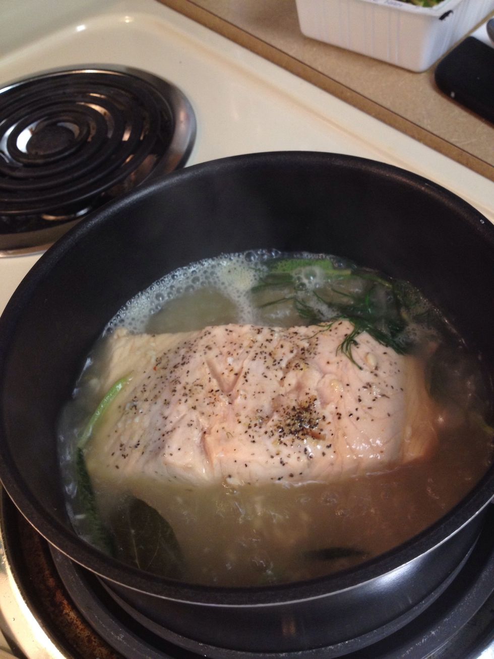 Put in the lid slightly open and poach the salmon for 15 min controlling the temp not to boil too hard. Check if the fish is done by pressing on the fish. It should feel firm.