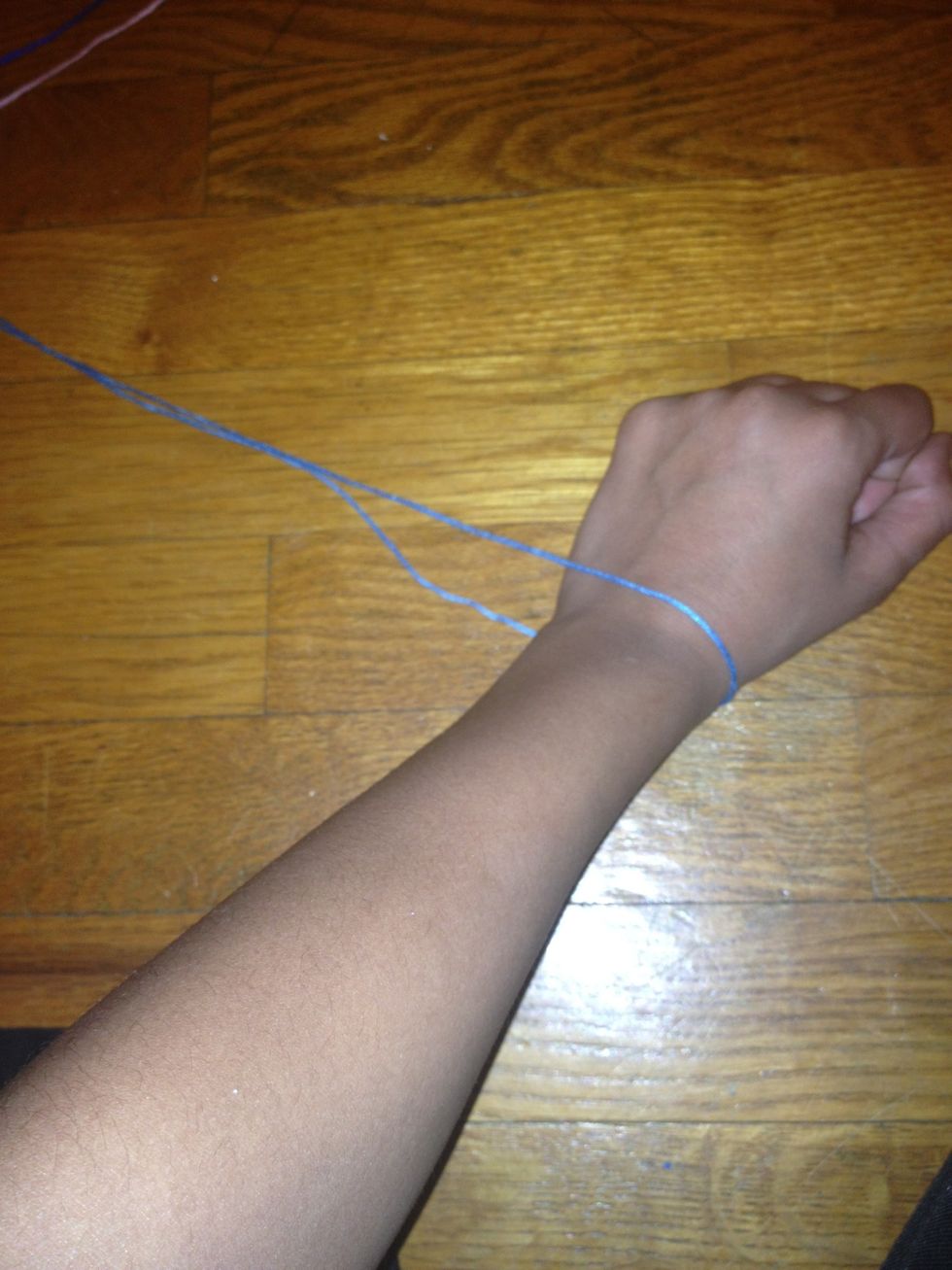 Put it around your wrist but make it a lot longer then you will need the string will get shorter