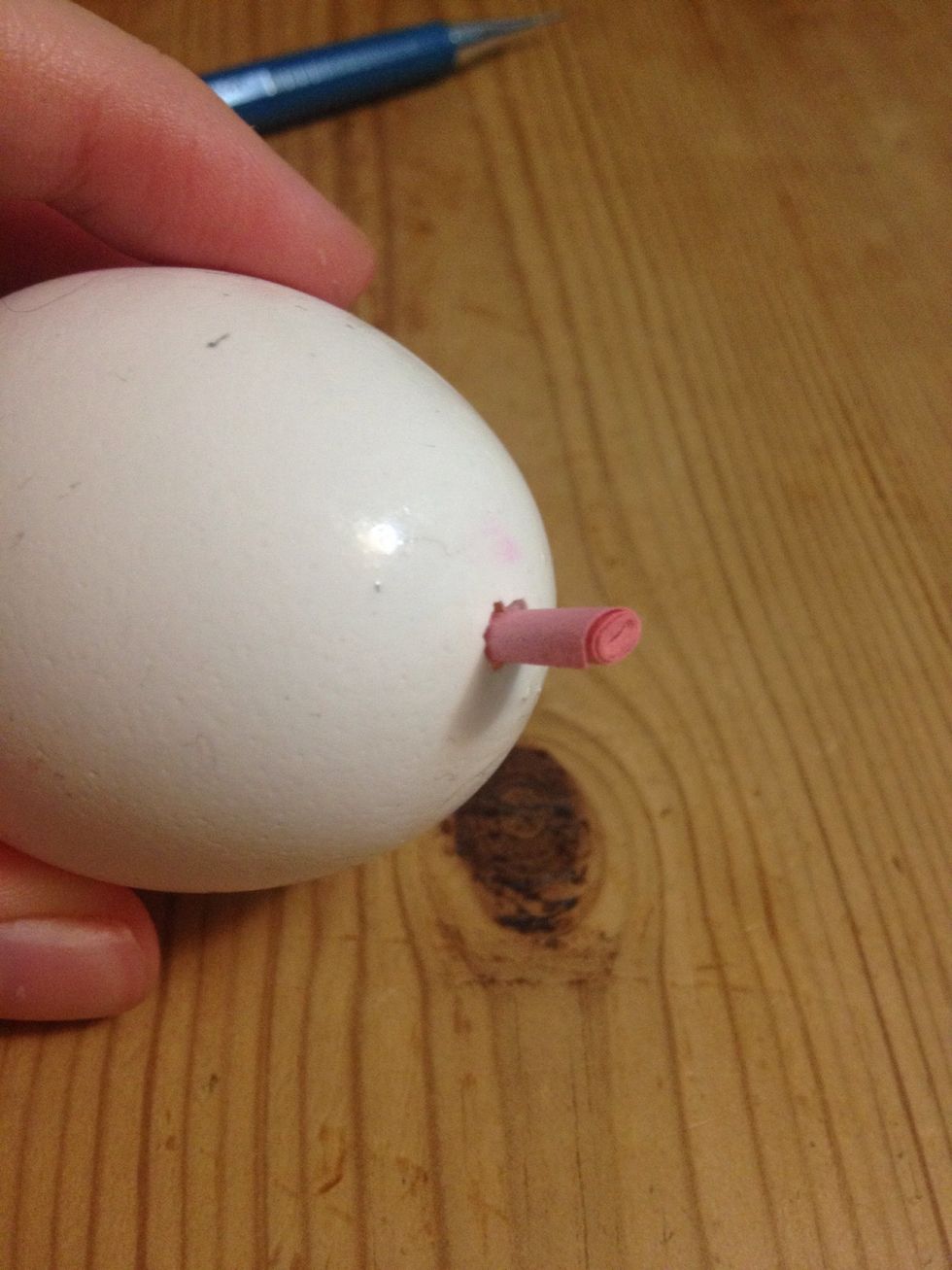 Put it into the egg through the side with the larger hole.