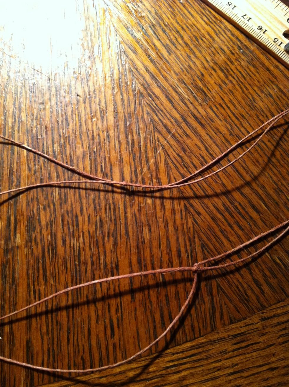 Put it on and measure it to a comfortable length. The strings hanging down are what you'll use to put your beads in. Don't cut them yet you still need extra to tie it off.