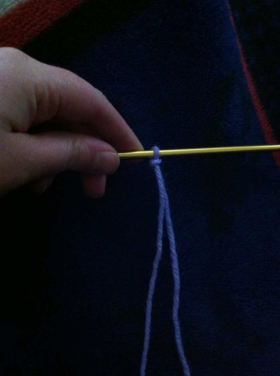 Put it on one of the knitting needles and tighten stitch.