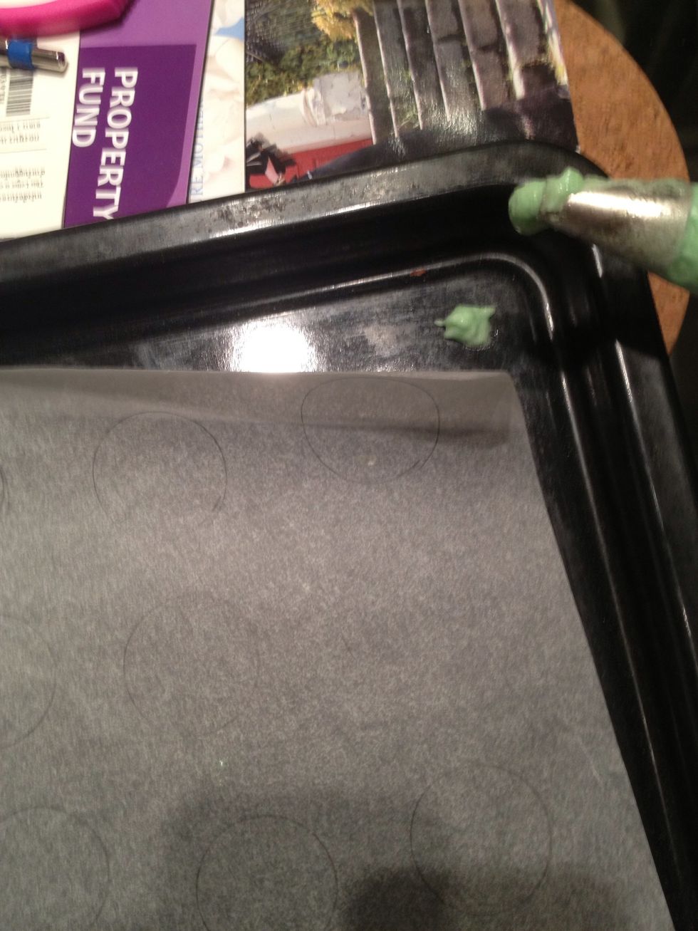 Put it pencil side down. Pipe some paste on a tray and stick the parchment to it. That way it's easier to pipe without the parchment flying up and down.