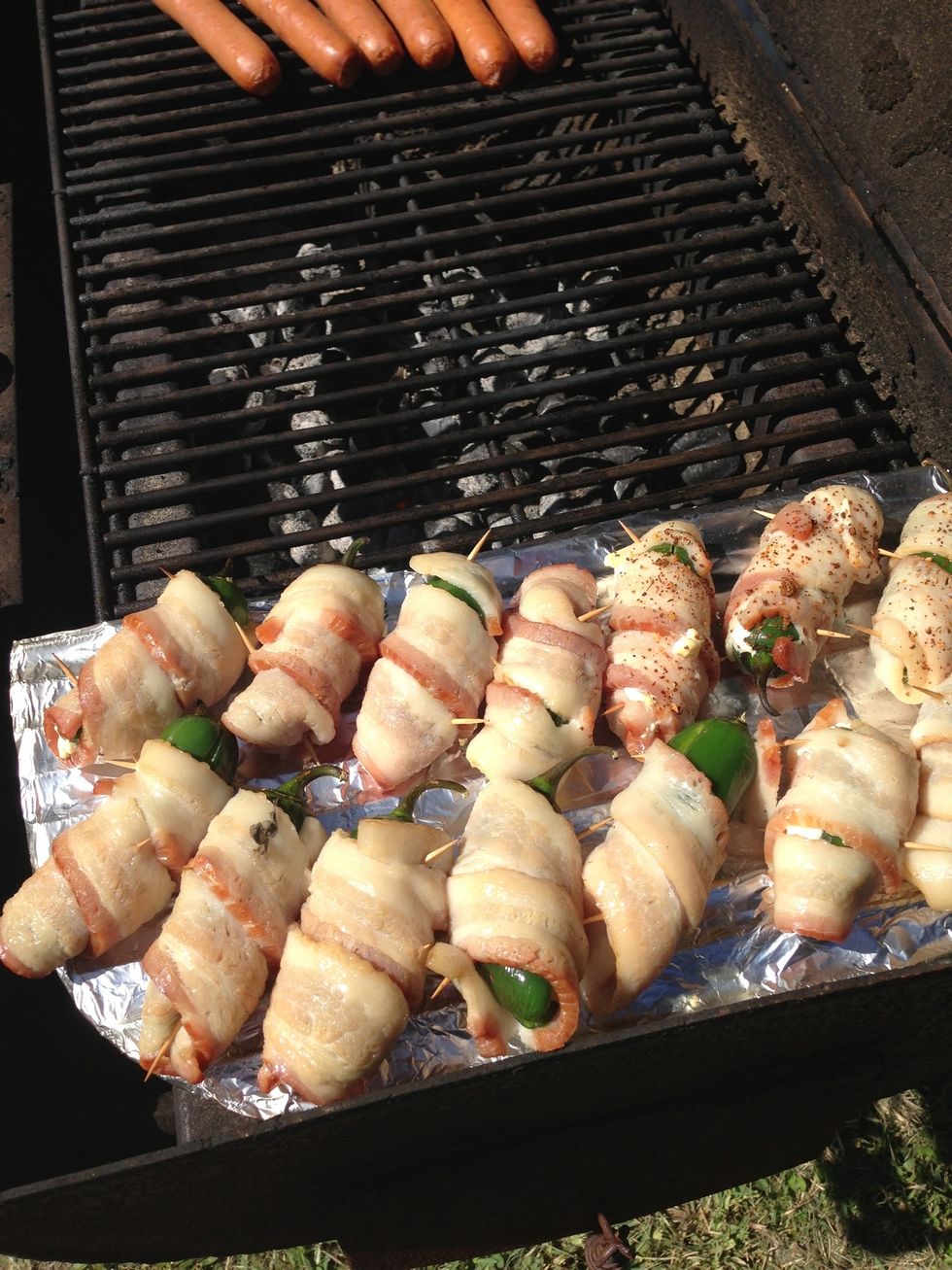 Put jalape\u00f1os on the top shelf of the pre heated grill or put on bottom right layer of the grill wrapped in aluminum foil. Depending on the heat, cook jalape\u00f1os until the bacon is fully cooked.